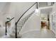 Elegant foyer with a curved staircase, white tile flooring, and abundant natural light at 7420 S Houstoun Waring Cir, Littleton, CO 80120