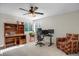 Bright office space with a ceiling fan, large window, desk, chair, and comfortable, colorful armchair at 7420 S Houstoun Waring Cir, Littleton, CO 80120
