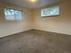 Finished basement with neutral walls and carpeting and natural light from two windows at 4115 S Vincennes Ct, Denver, CO 80237