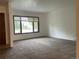 Bright, open living room featuring new carpeting and a large window for natural light at 4115 S Vincennes Ct, Denver, CO 80237