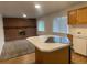 Kitchen with an island cooktop overlooking the living room with a brick fireplace at 4115 S Vincennes Ct, Denver, CO 80237