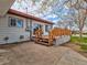 Wooden deck, concrete patio, and siding of home with a glimpse of the blue sky at 940 S Geneva St, Aurora, CO 80247