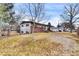 View of the property's backyard, featuring mature trees, a fence, and a view of the house at 940 S Geneva St, Aurora, CO 80247