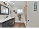 Bathroom with a black vanity, decorative mirror, and combination shower and tub at 940 S Geneva St, Aurora, CO 80247