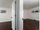 Bright bedroom featuring dark wood floors, white walls, and a view through the doorway at 940 S Geneva St, Aurora, CO 80247