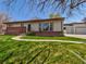 Well-kept ranch home features a brick accent, grassy yard, and walkway to the front door at 940 S Geneva St, Aurora, CO 80247