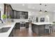 Open kitchen with stainless steel appliances, dark wood cabinets, and a large kitchen island at 940 S Geneva St, Aurora, CO 80247