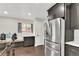 Kitchen nook with stainless steel refrigerator, dark wood cabinets, and natural light at 940 S Geneva St, Aurora, CO 80247