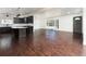 Hardwood floors leading to a kitchen area with island and dark cabinets at 940 S Geneva St, Aurora, CO 80247
