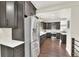 Modern kitchen featuring stainless steel appliances, dark wood cabinets, and hardwood floors at 940 S Geneva St, Aurora, CO 80247