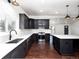 Bright kitchen features stainless steel appliances, dark cabinets, white countertops, and dark hardwood floors, blending style and functionality at 940 S Geneva St, Aurora, CO 80247