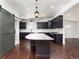 Modern kitchen with dark cabinets, a central island, and stainless steel appliances exudes elegance and functionality at 940 S Geneva St, Aurora, CO 80247