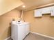 Well-lit laundry room with white washer and dryer, plus cabinets for storage at 940 S Geneva St, Aurora, CO 80247