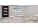 Bright living room featuring modern gray vinyl flooring, light gray walls, and stylish front door and window at 4611 W 2Nd Ave, Denver, CO 80219