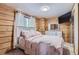 Charming bedroom with a cozy bed and wood-paneled walls at 7350 Fremont Pl, Larkspur, CO 80118