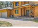 Log home's entrance with a covered porch and stone accents at 7350 Fremont Pl, Larkspur, CO 80118