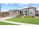 Charming home featuring a well-manicured lawn, stone accents, a two-car garage, and inviting front porch at 22580 E Eads Cir, Aurora, CO 80016