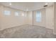 This neutral toned bedroom is bright and airy with multiple windows and gray carpet at 553 Homestead Ave, Brighton, CO 80601