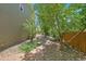 Landscaped backyard with brick path, mature trees, and wooden fence for privacy at 16500 Hitching Post Cir, Parker, CO 80134