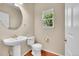 Bright half bathroom features a pedestal sink, wood floors, and a window providing natural light at 16500 Hitching Post Cir, Parker, CO 80134