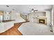 Open concept living room with a fireplace and adjacent kitchen with hardwood floors at 16500 Hitching Post Cir, Parker, CO 80134