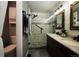 Stunning bathroom featuring double sinks, a glass shower with mosaic tile, and unique industrial-style mirrors at 17145 Park Trail Dr, Monument, CO 80132