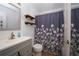 Bathroom with modern vanity, decorative shelves and a shower-tub combo with curtain at 17145 Park Trail Dr, Monument, CO 80132