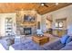 Living room with stone fireplace and large TV at 6220 Arapahoe Dr, Evergreen, CO 80439