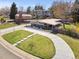 A modern style home with a curved driveway, solar panels, and well manicured lawn and garden at 3383 S Boston Ct, Denver, CO 80231