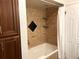 Full bathroom features neutral tile surround, built-in shelves, and shower with tub at 2261 W Briarwood Ave, Littleton, CO 80120