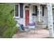 Cozy front porch with comfortable seating and a charming exterior with black shutters and a red front door at 2261 W Briarwood Ave, Littleton, CO 80120