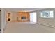 Spacious living room featuring a stone fireplace, neutral carpeting, and ample natural light from a large window at 2261 W Briarwood Ave, Littleton, CO 80120