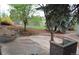 Spacious backyard patio with mature trees, landscaping, and charming stone and brick elements at 2261 W Briarwood Ave, Littleton, CO 80120