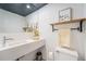Modern bathroom boasts a sleek vanity with integrated sink, floating wood shelf, and minimalist decor at 200 N Sherman St # 2, Denver, CO 80203