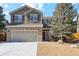 Charming two-story home featuring a well-maintained lawn, brick accents, and an attached two-car garage at 7453 S Norfolk St, Aurora, CO 80016