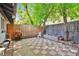 Red and white checkered patio with grill, chair, planting box, and shade trees and privacy fence at 2955 N Gilpin St, Denver, CO 80205