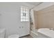 Bright bathroom with a window, tub and shower combination, and neutral tile at 2955 N Gilpin St, Denver, CO 80205