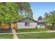 Charming home with a well-maintained lawn, grey brick exterior, and privacy fence at 2955 N Gilpin St, Denver, CO 80205