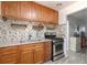 Well-lit kitchen featuring a stainless steel stove, granite counters, and mosaic backsplash at 2955 N Gilpin St, Denver, CO 80205