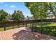 Large wood deck with black railings overlooks the beautifully landscaped backyard with mature trees and privacy fence at 9564 Cordova Dr, Highlands Ranch, CO 80130