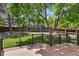 Backyard view showcasing the wooden deck with black railings, mature trees, and fenced perimeter at 9564 Cordova Dr, Highlands Ranch, CO 80130
