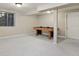 Finished basement features neutral paint, carpet, and a large window for natural light, adjacent to a pool table at 9564 Cordova Dr, Highlands Ranch, CO 80130