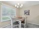 Bright dining room features a modern chandelier, a square table and sun-lit window at 9564 Cordova Dr, Highlands Ranch, CO 80130