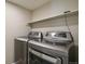 Modern laundry room with front loading washer and dryer and utility shelving at 9564 Cordova Dr, Highlands Ranch, CO 80130