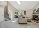 Bright living room with vaulted ceiling, skylight, brick fireplace, and staircase with landing at 9564 Cordova Dr, Highlands Ranch, CO 80130