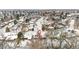 An aerial view of a snow-covered neighborhood with mature trees and residential homes at 2842 S Newport St, Denver, CO 80224