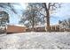 View of backyard, shed and back of home covered in snow at 2842 S Newport St, Denver, CO 80224