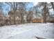 Snow-covered backyard with trees and storage shed at 2842 S Newport St, Denver, CO 80224