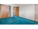 Bedroom featuring closet with sliding doors, bright teal carpeting, and ensuite bath at 2842 S Newport St, Denver, CO 80224