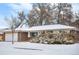 Exterior of a brick and siding home featuring an attached garage and snow-covered front lawn at 2842 S Newport St, Denver, CO 80224